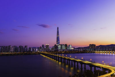 Illuminated buildings against sky at dusk