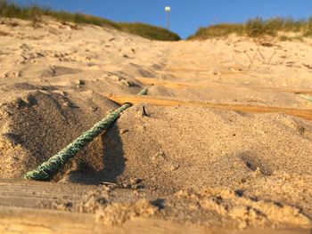 Close-up of hanging ladder on sand