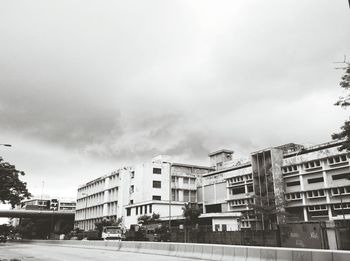 Buildings in city against cloudy sky