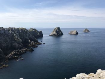 Scenic view of rocks in sea against sky