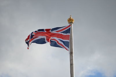 Low angle view of british flag against cloudy sky