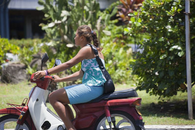 Side view of woman riding motorcycle