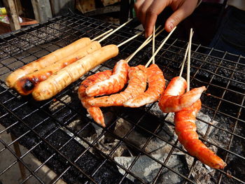 High angle view of fish sausages and prawns on barbecue grill in laos.