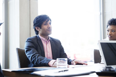 Businessman discussing with colleagues during meeting in office