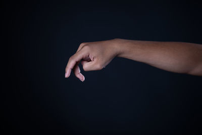 Close-up of woman hand against black background