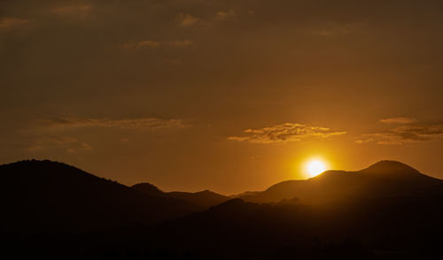 Scenic view of silhouette mountains against sky at sunset