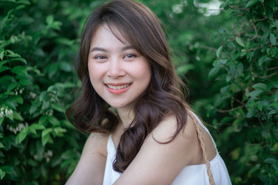 Portrait of smiling woman by plants