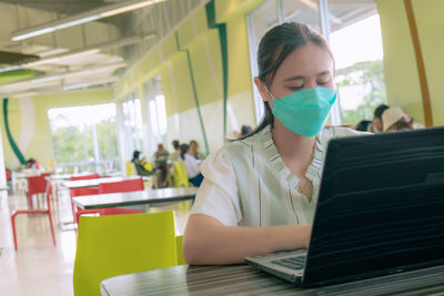 Asian women  to work outside office at the food court the shopping center wearing a mask for safety 