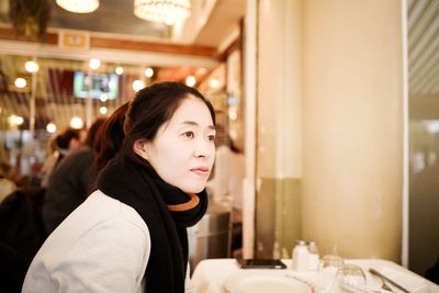 Young woman sitting at table in restaurant