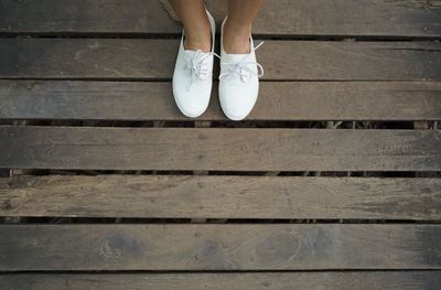 Low section of woman standing on wooden floor