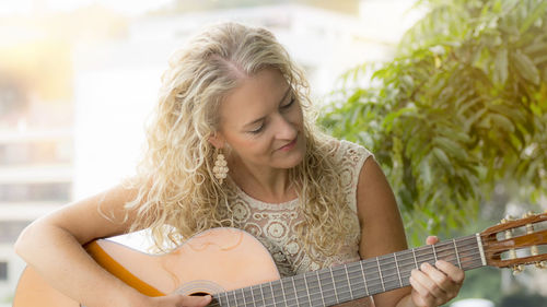 Portrait of a young woman playing guitar