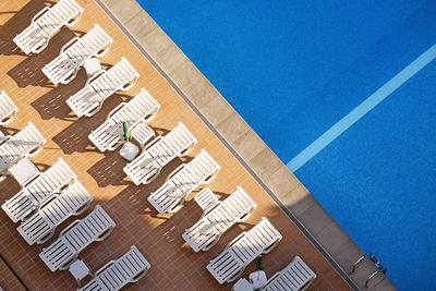 Swimming pool exterior with  white loungers in hotel