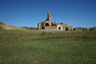 Built structure on field against clear sky