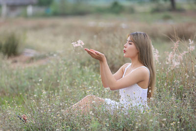 Side view of young woman on grassy field