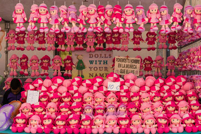 Vendor selling pink dolls at market stall