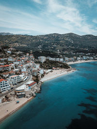 High angle view of townscape by sea against sky