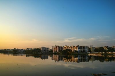 Reflection of buildings in city at sunset