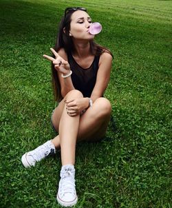 Woman blowing bubble gum while gesturing on field