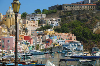 Sailboats moored on harbor by buildings in town