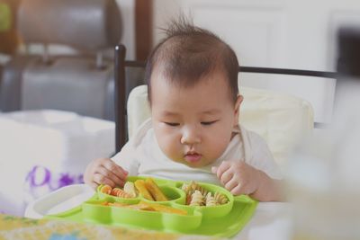 Portrait of boy eating food at home