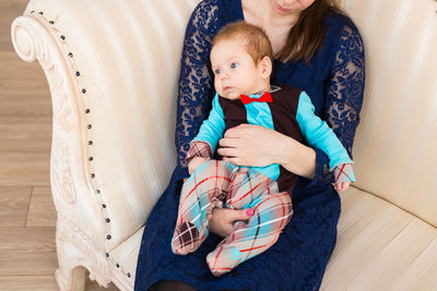 Full length of mother and woman sitting at home