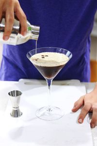 Midsection of man pouring coffee in cup on table