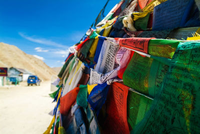 Close-up of multi colored flags hanging against the sky