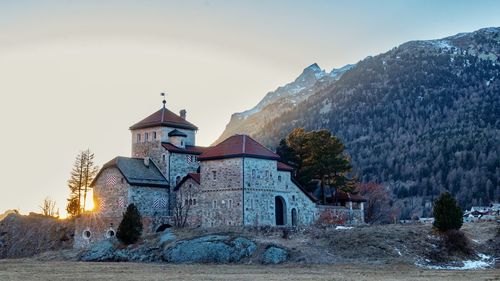 Church by building against sky during winter