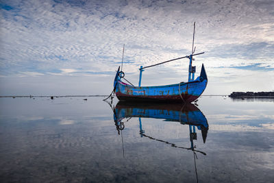 Fishing boat in sea against sky