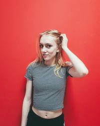 Portrait of a beautiful young woman against red background