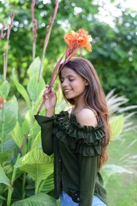 Young woman smiling while standing on plant