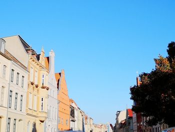 Low angle view of buildings against clear blue sky