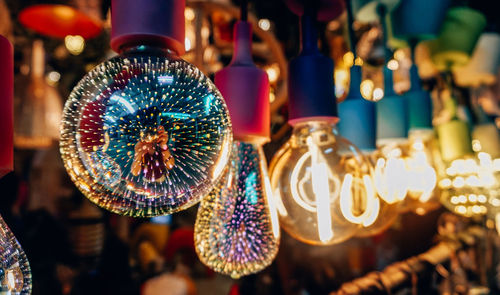 Close-up of illuminated lanterns hanging at market stall