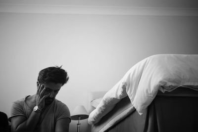 People sitting on bed against wall at home