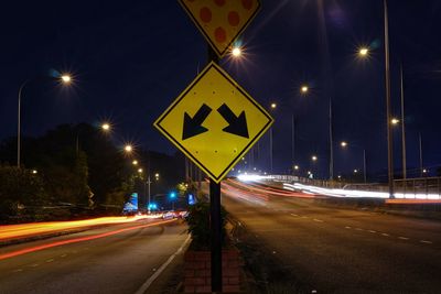 Close-up of arrow symbols on road at night