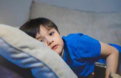 Portrait of boy lying at home