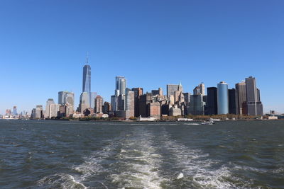 City at waterfront against clear sky