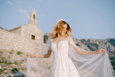 Bride standing against church