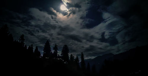 Silhouette trees in forest against sky at night