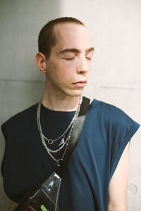 Young man standing against wall