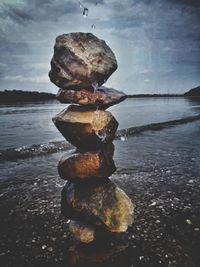 Stack of rock on beach against sky