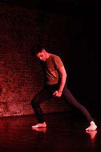 Full length of senior woman dancing against black background