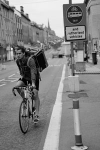 Man riding bicycle on road in city