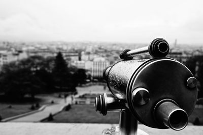 Close-up of coin operated binoculars facing cityscape