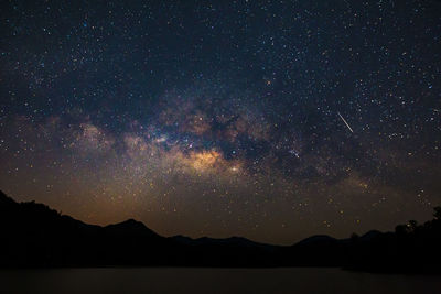 Scenic view of silhouette mountains against sky at night