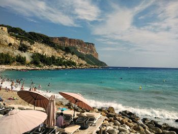 Scenic view of beach against cloudy sky