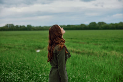 Young woman day dreaming with eyes closed in field