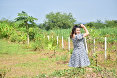 Portrait of young woman standing on field