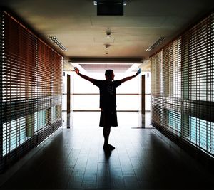 Full length rear view of woman standing in corridor