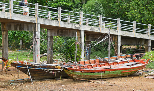 Boats on field against bridge